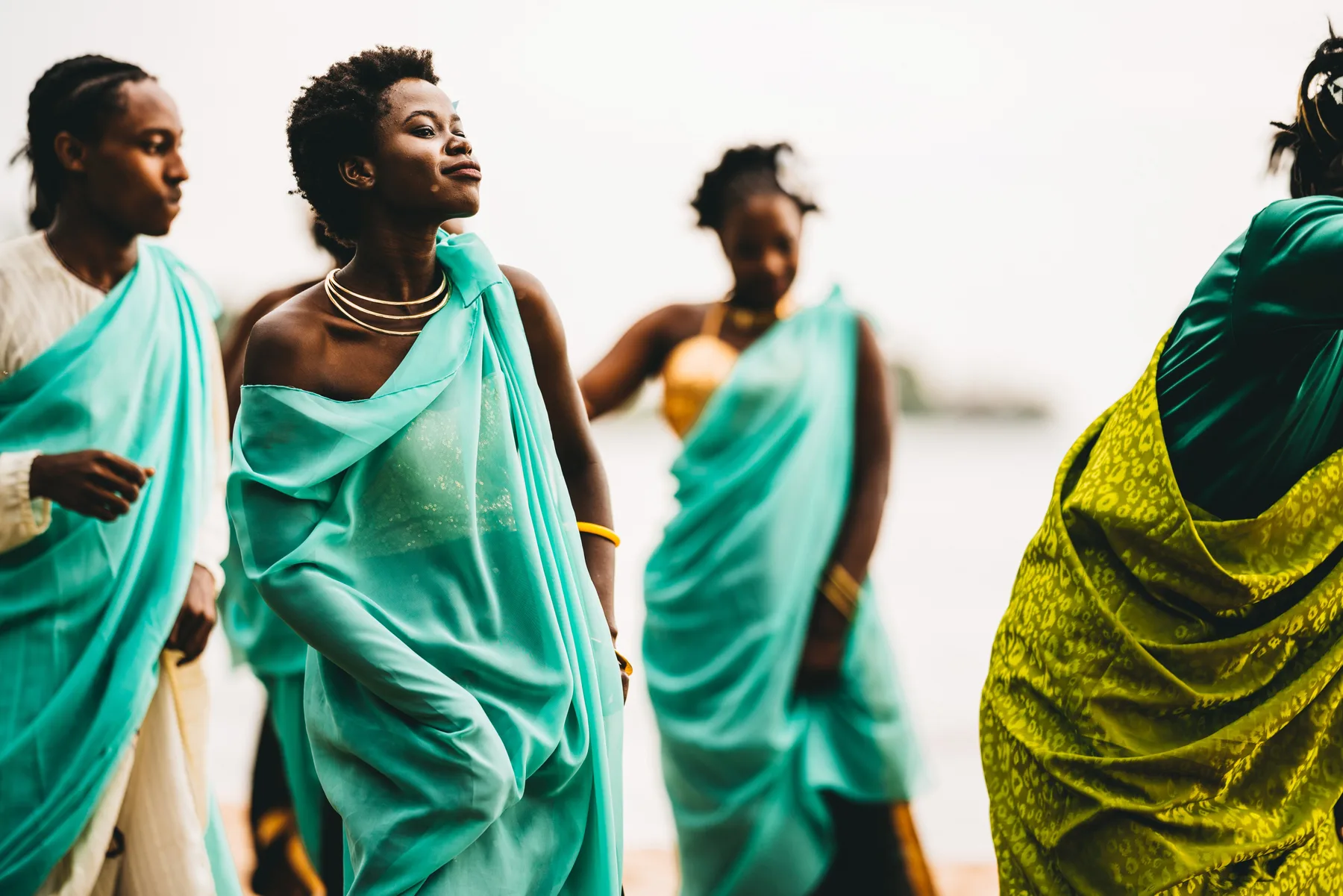Wedding party members in turquoise attire during an outdoor celebration