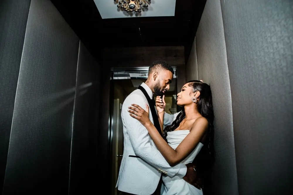 Abigail and Dontre share a close embrace in a dim hallway