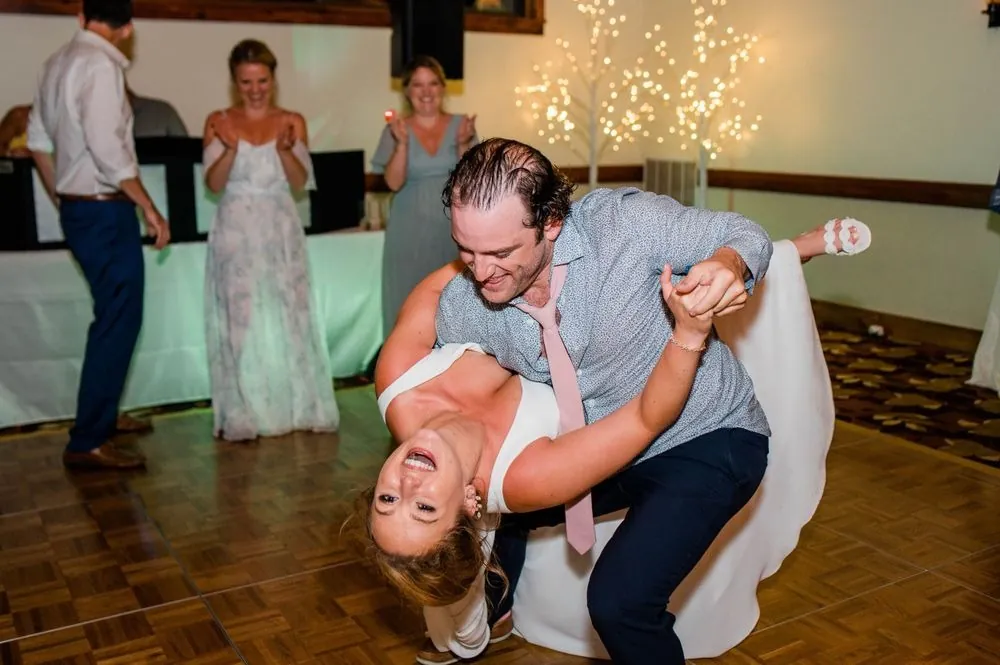 Robert dips Alexandra low on the dance floor as guests laugh