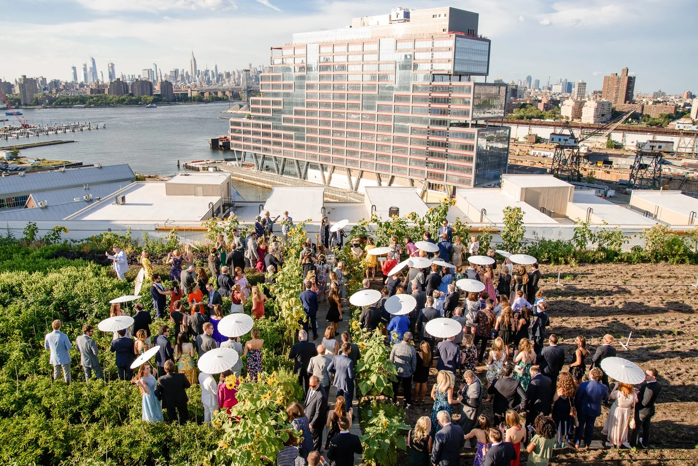 Guests gather in the rooftop planting rows for the ceremony, with the city behind them