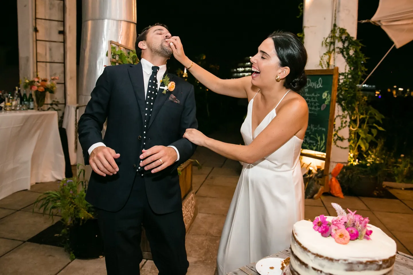 Alexis feeds David a bite of flower-topped cake as he laughs