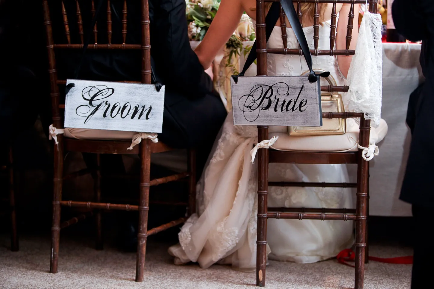 Chairs marked Bride and Groom sit side by side at the table