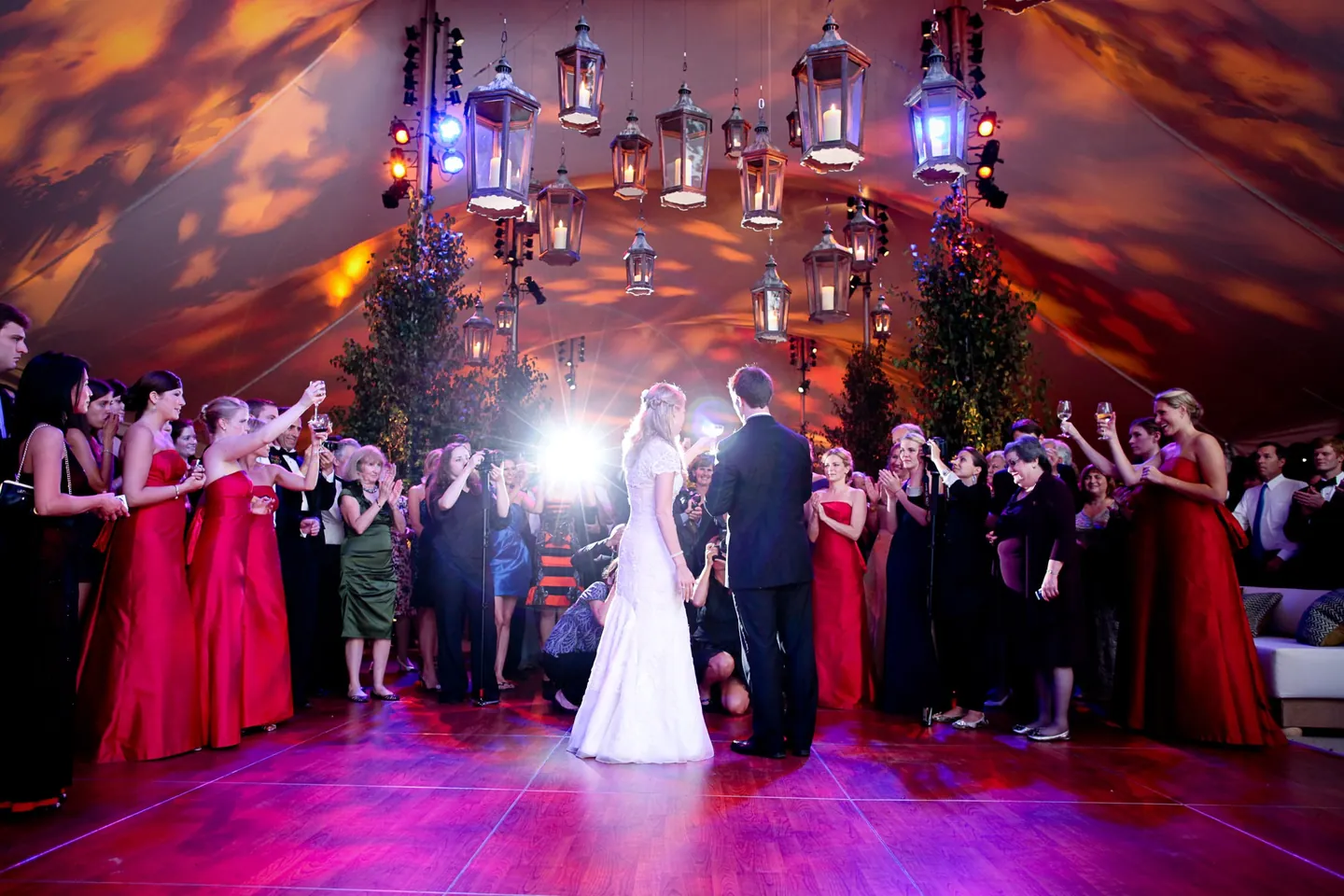 Alli and Dave share their first dance as bridesmaids raise glasses around them