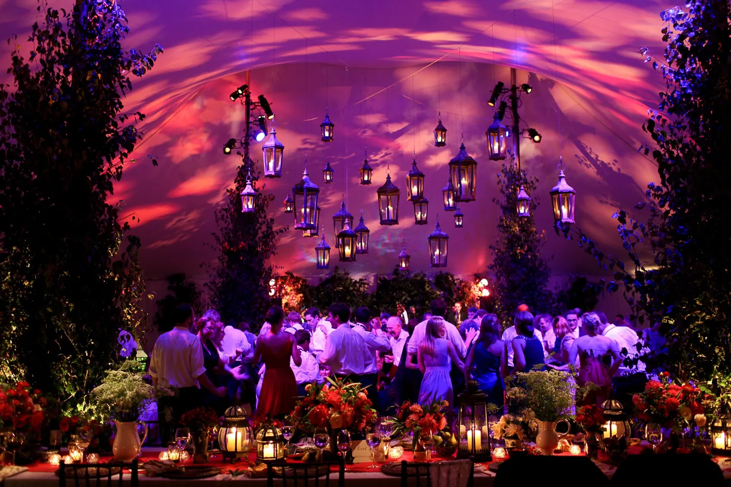 The tent ceiling glows purple and orange above a packed dance floor