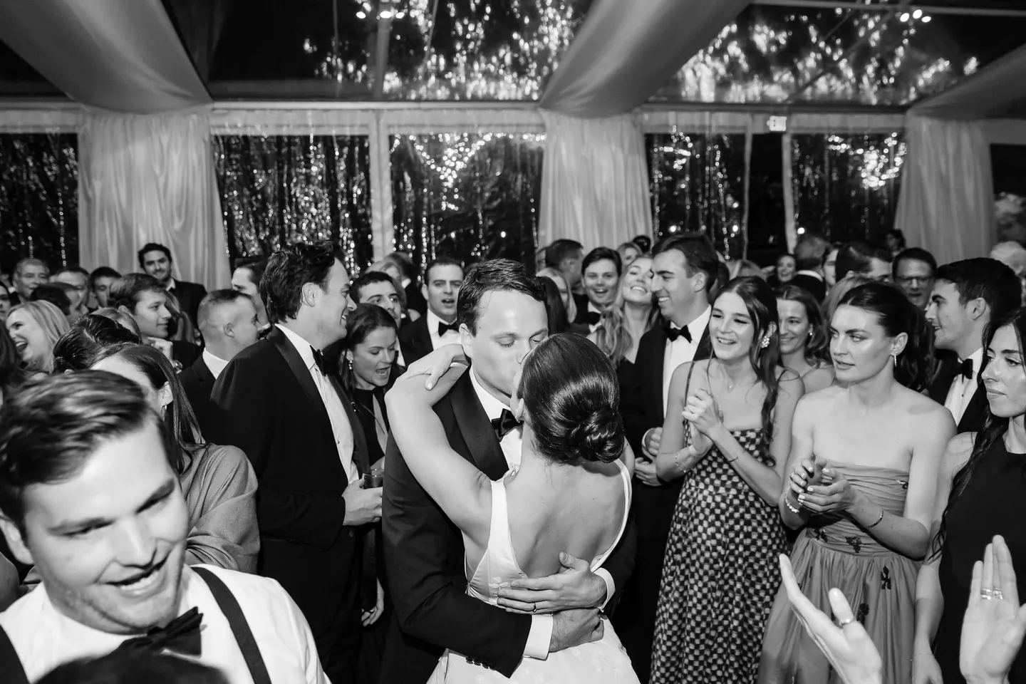 The couple dance in the middle of a crowded floor, arms around each other