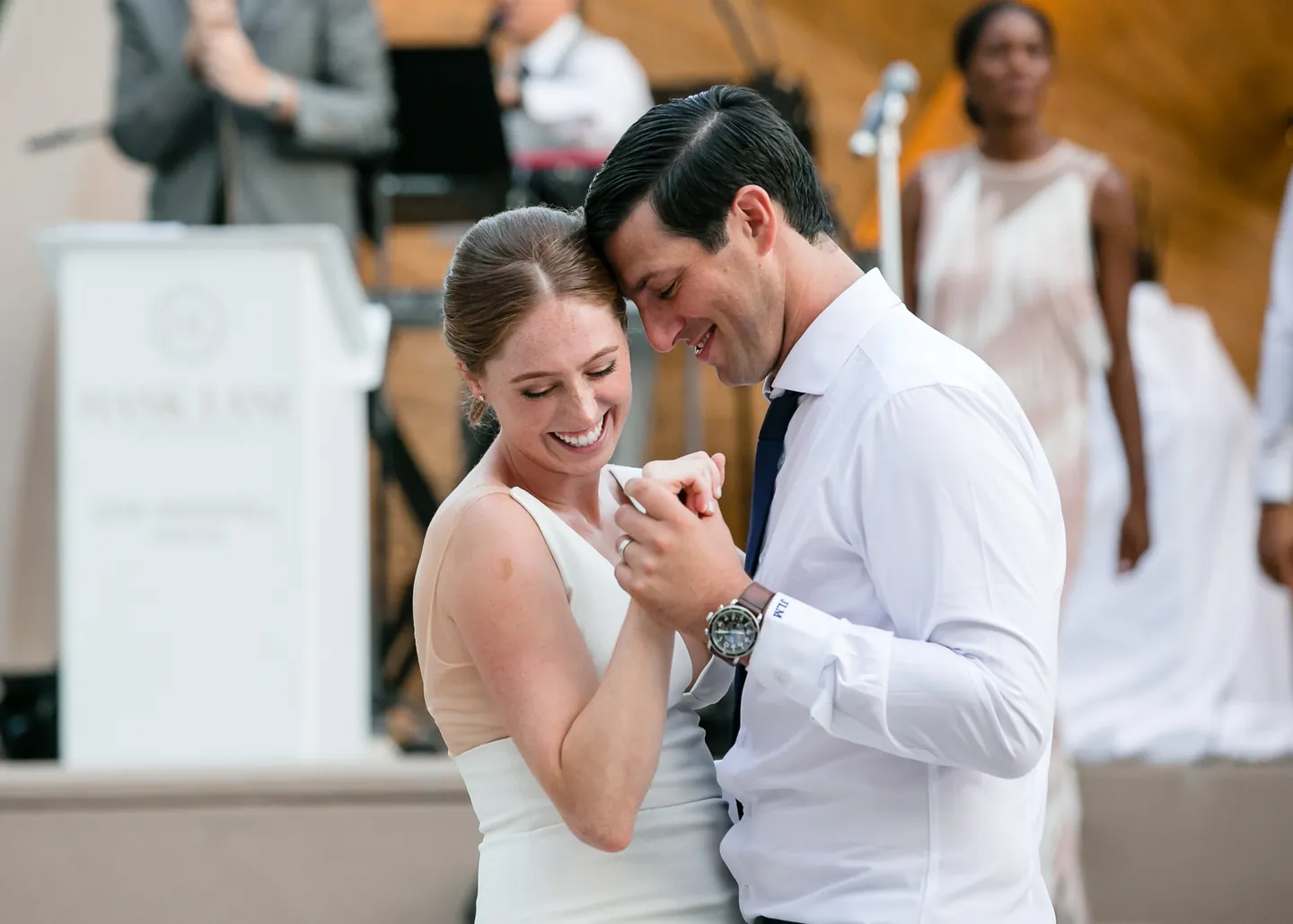 Anna and John laugh forehead to forehead on the dance floor