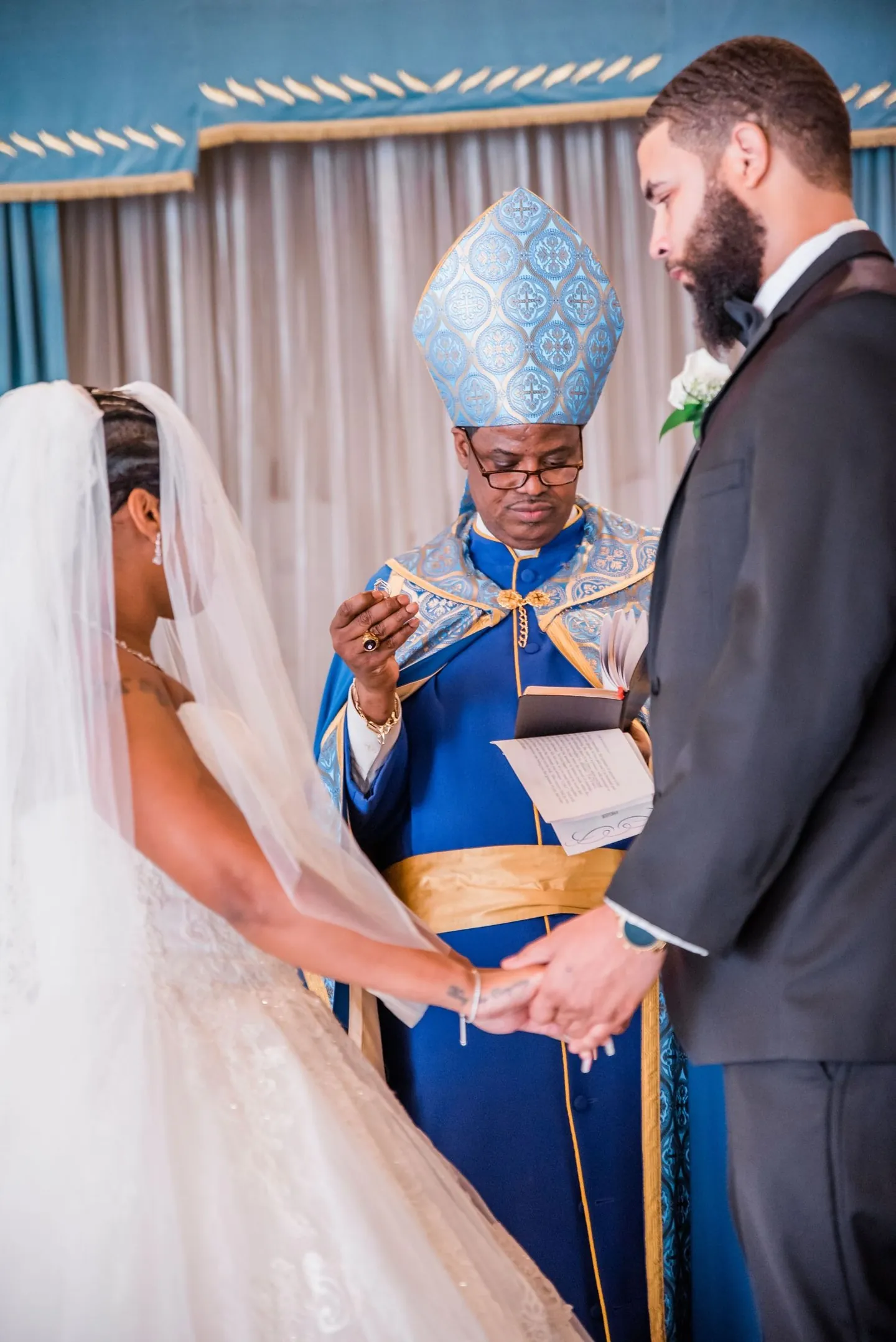 The officiant joins Ashley and Darren's hands during their vows