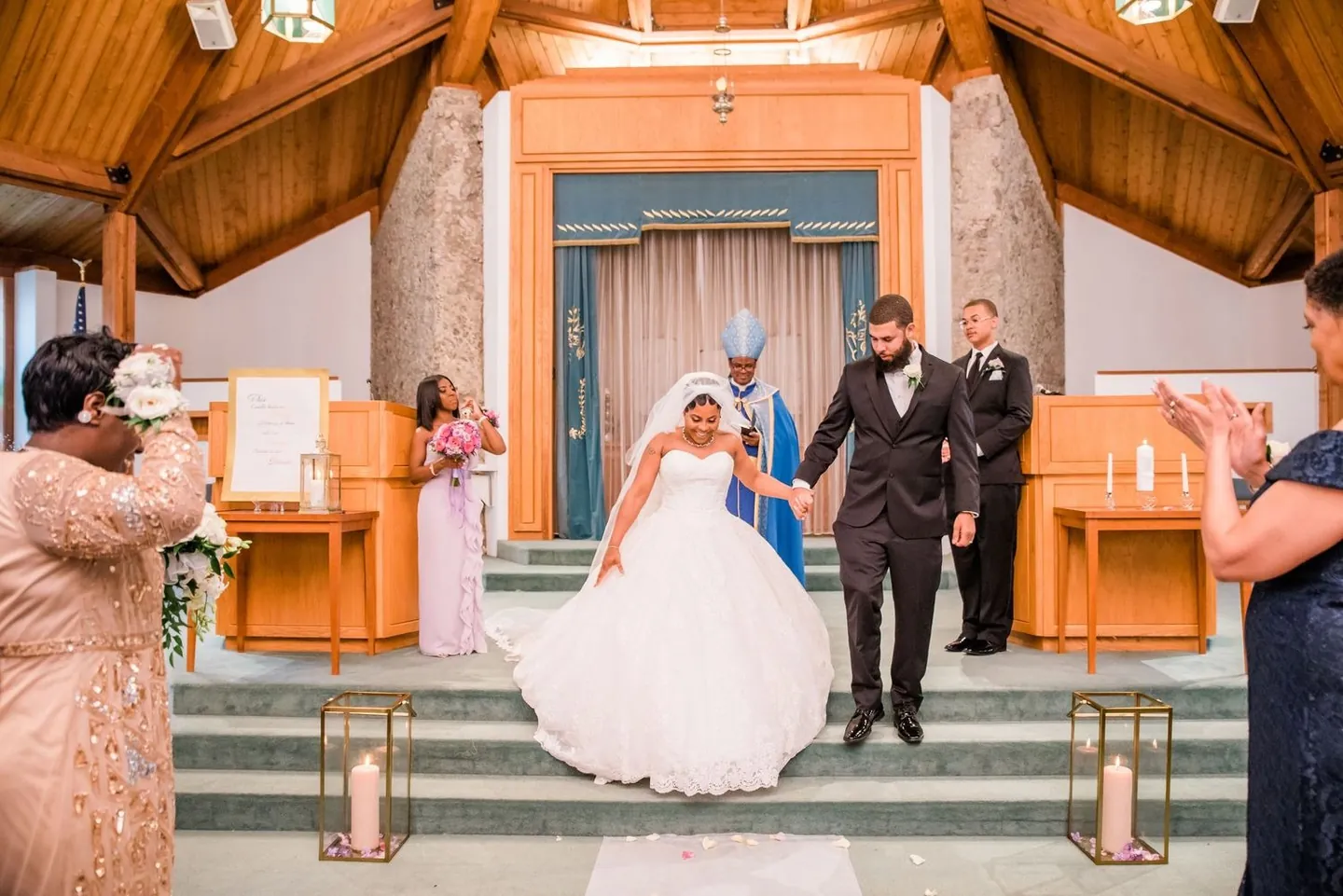 Ashley and Darren come down the altar steps as family applauds