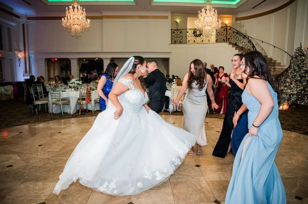 The bride spins on the dance floor surrounded by guests