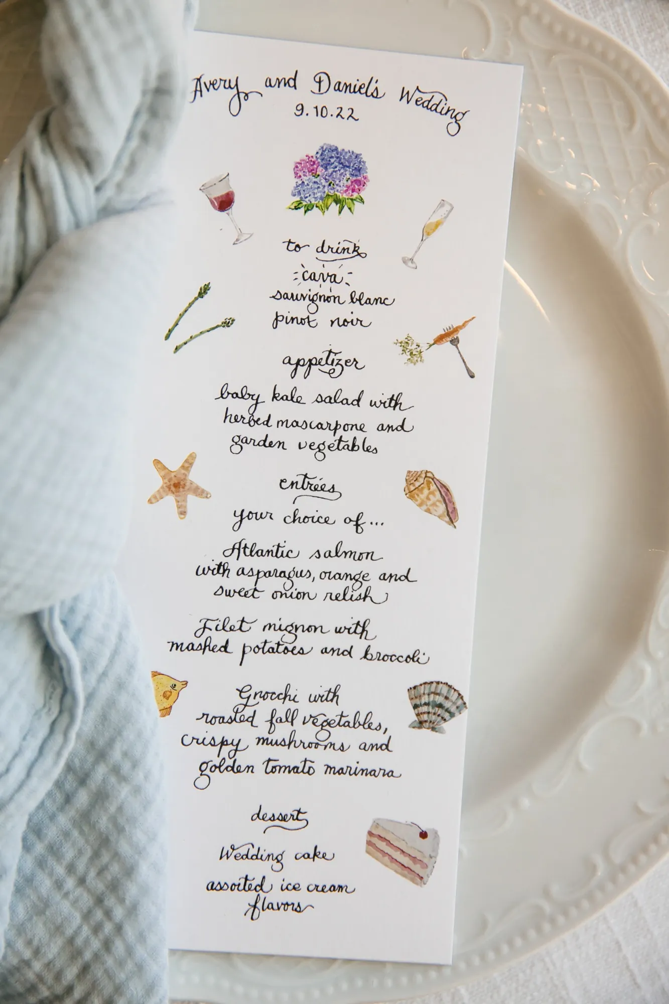 A hand-illustrated dinner menu with little seaside drawings resting on a white plate