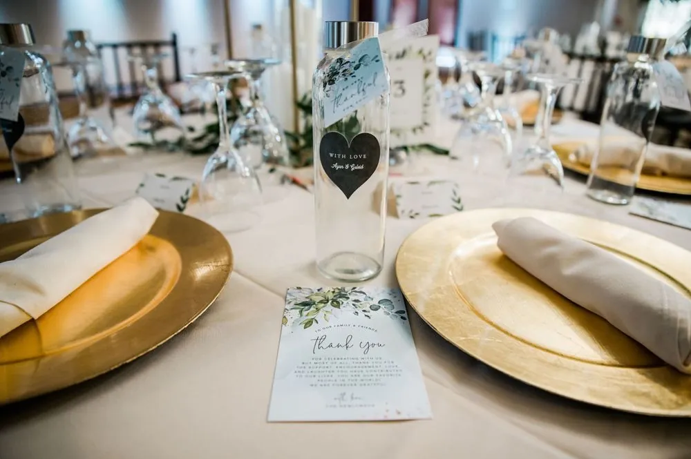 Gold chargers, white napkins and menu cards set at the reception tables