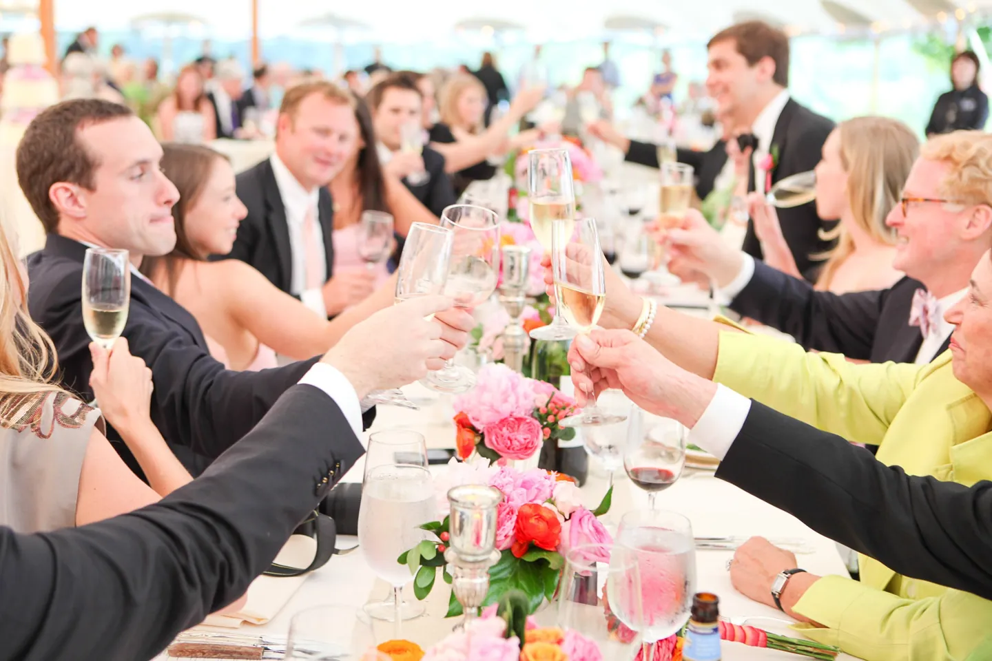 Guests reach across the table to clink glasses during the toasts