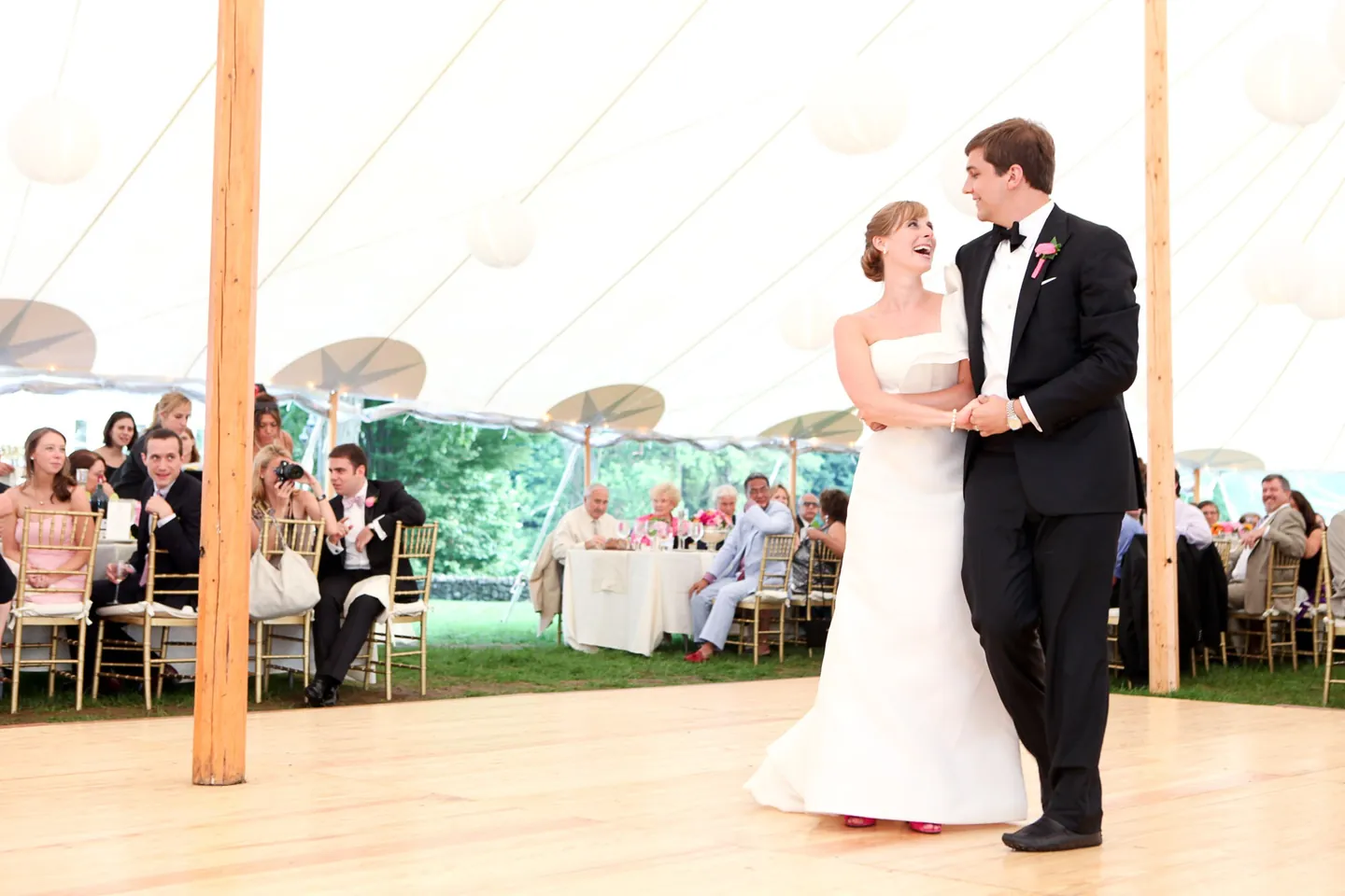 Caity and Matt share their first dance under the tent as guests watch