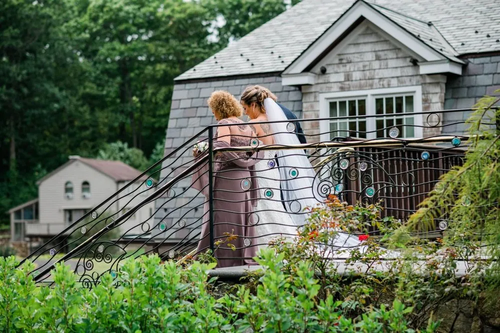 Wide view of the couple at the top of the stone stairs beside the clubhouse