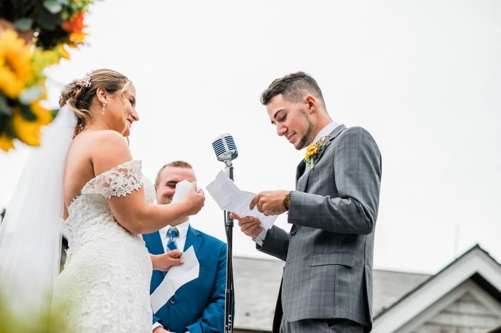 Caroline and Zachary read vows from folded pages into a vintage microphone