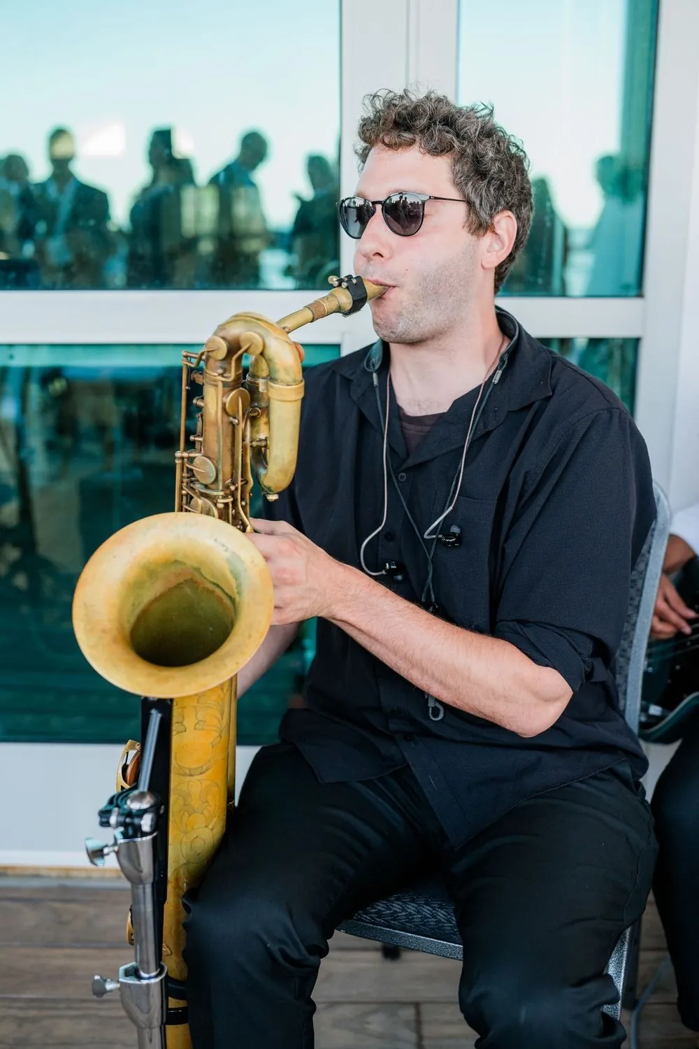 Saxophonist in sunglasses plays during cocktail hour on the pavilion deck