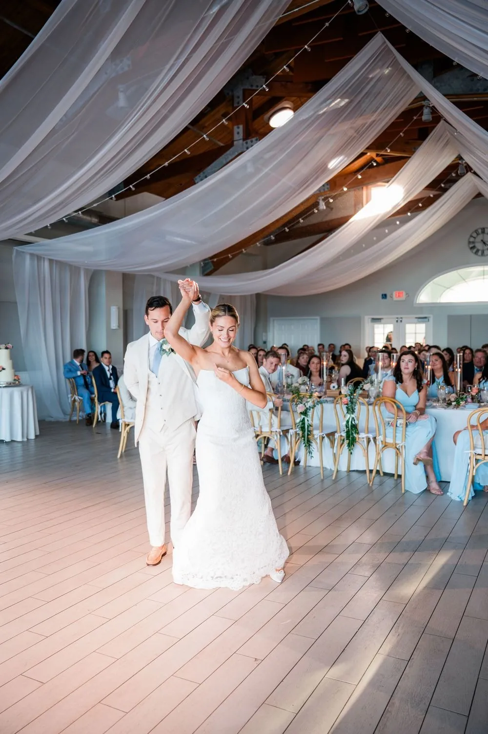 First dance under white draped ceiling fabric as guests watch from their tables