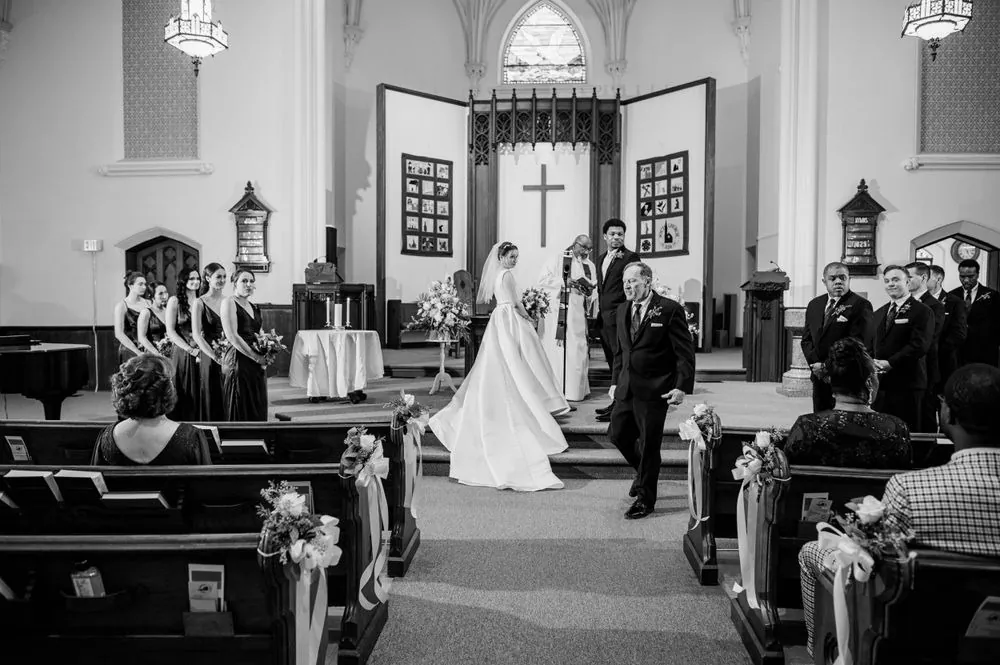 Black and white of the couple walking back up the church aisle