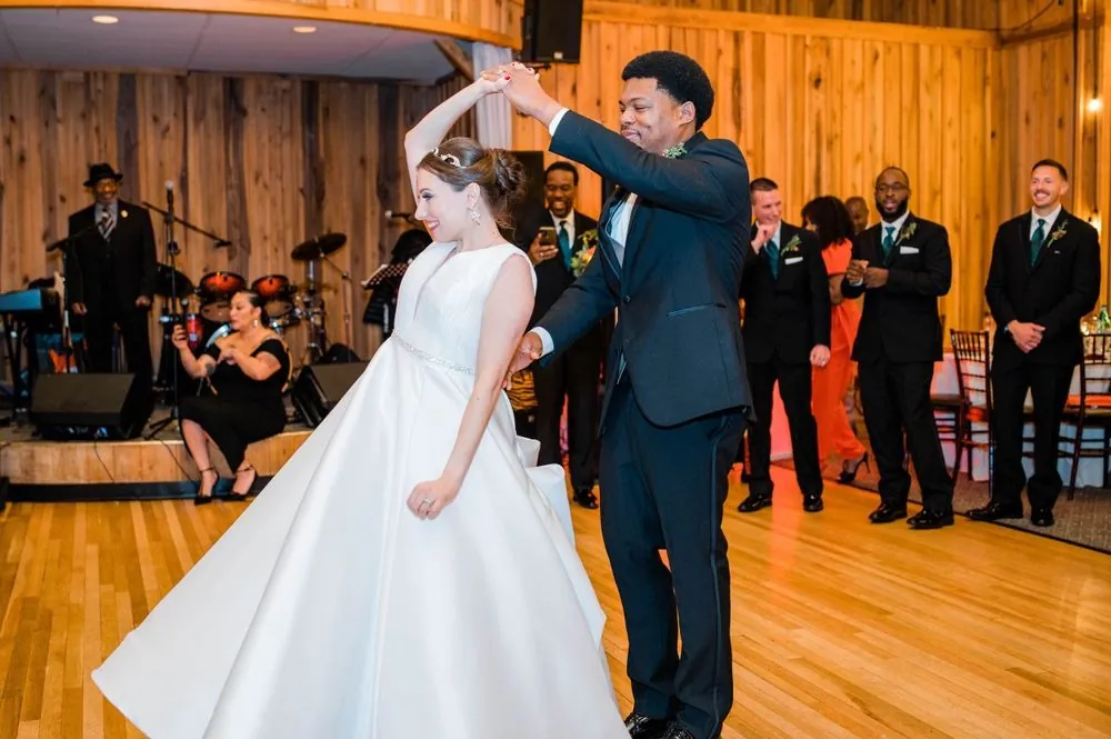 Claude spins Rebecca across the wood dance floor as guests watch