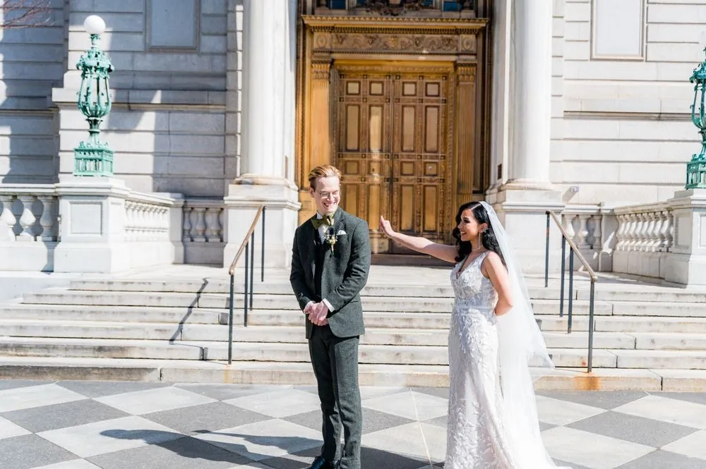 Victoria walks up behind Colin for their first look on the checkerboard plaza at City Hall