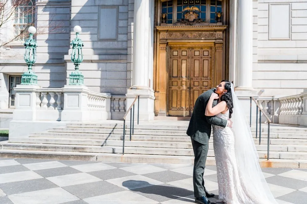 Victoria and Colin embrace at the foot of the City Hall steps after their first look
