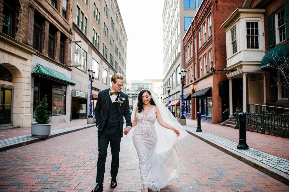 Victoria and Colin walk a brick downtown street lined with shops