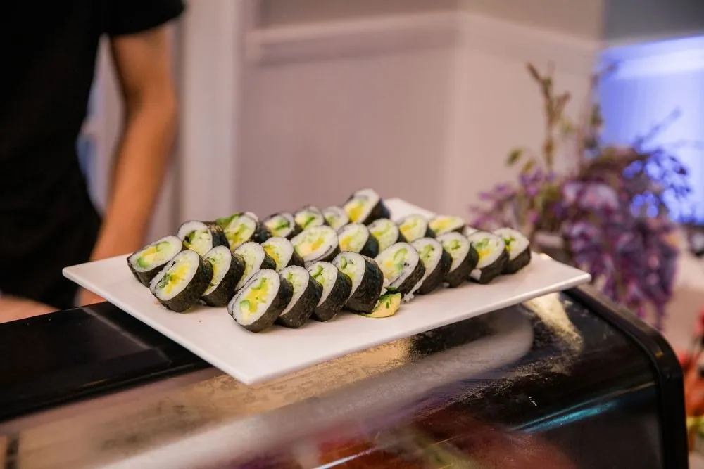 White platter of sushi rolls on the bar during cocktail hour