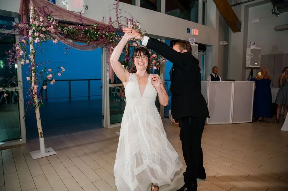 Michael spins Dana on the tiled dance floor beside the blossom arch and glass wall