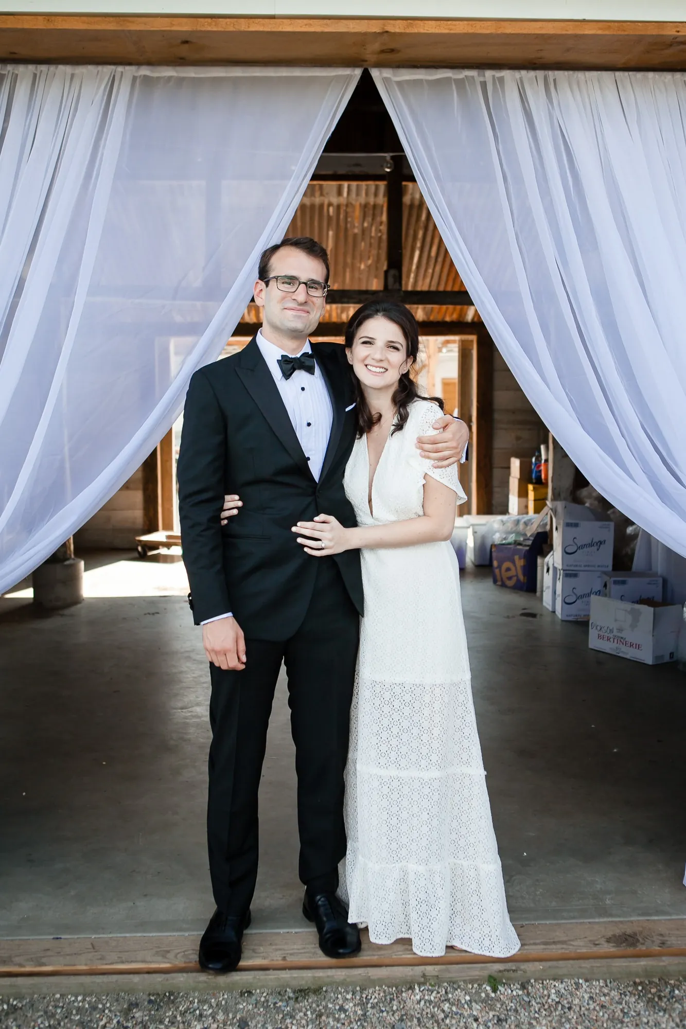 EJ and Alex pose in a barn doorway framed by white curtains