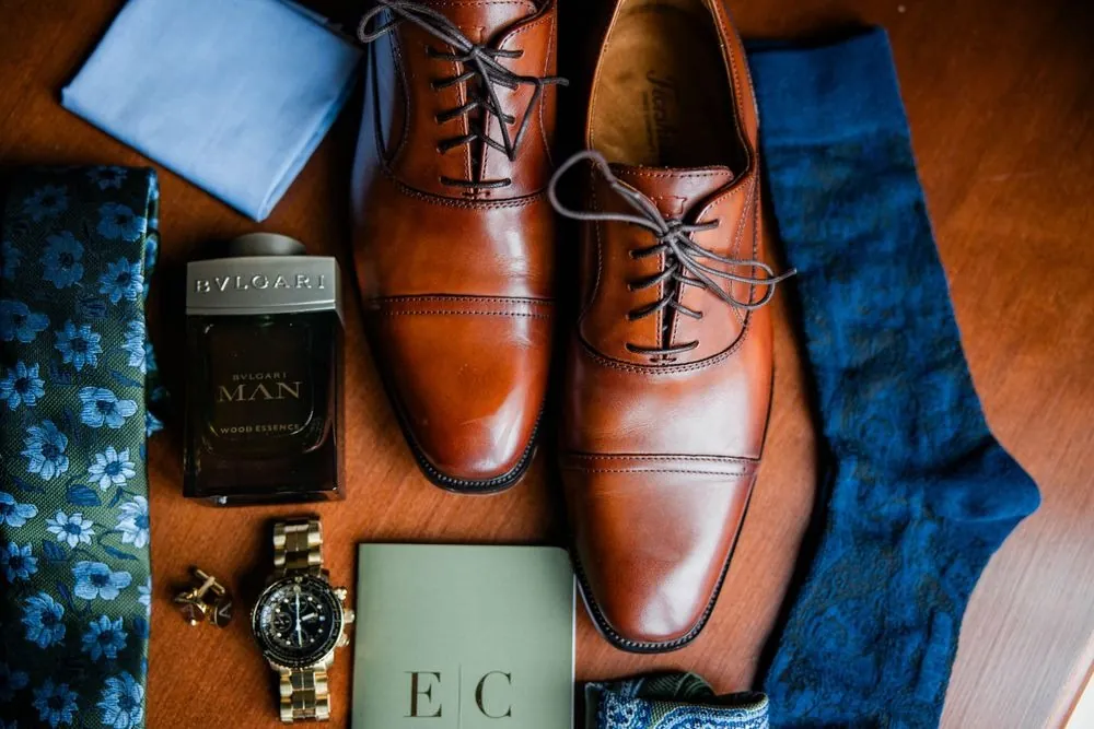 Brown leather oxfords, patterned blue socks and a watch laid out for the groom