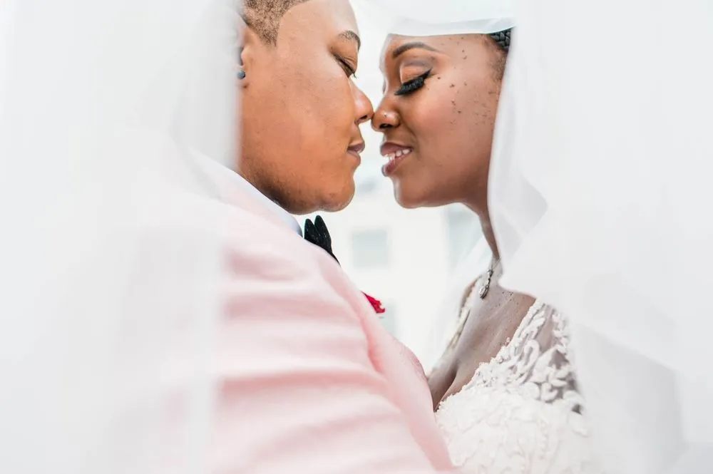 Erin and Sheretha rest their foreheads together under a sheer veil