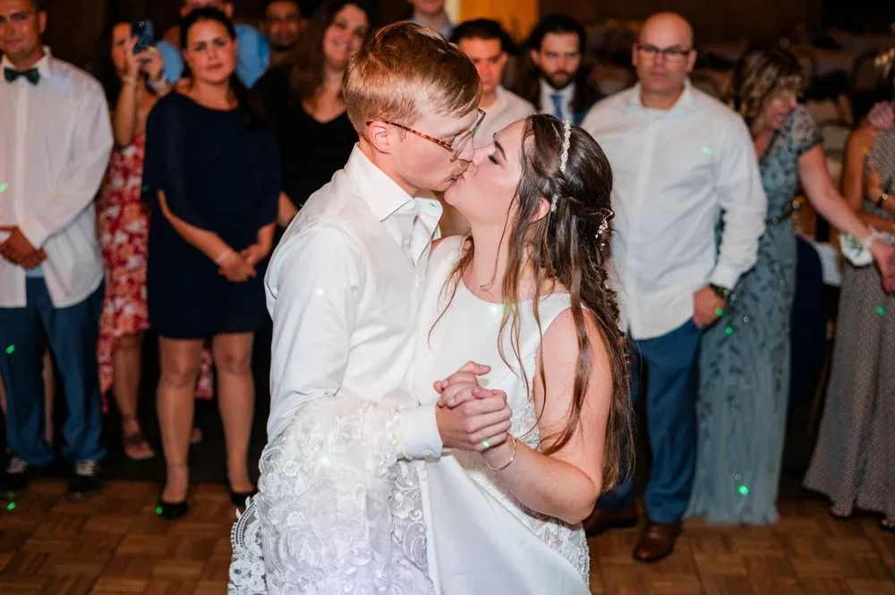 The couple kisses in the middle of the crowded dance floor late in the night
