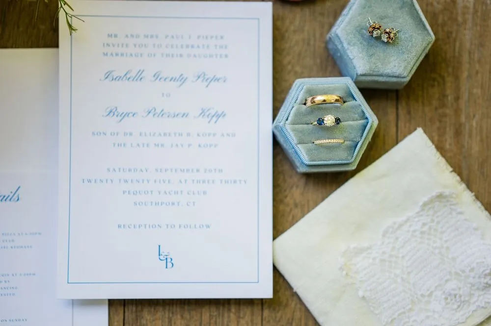 Letterpress invitation with a pale blue ring box and handmade paper on wood