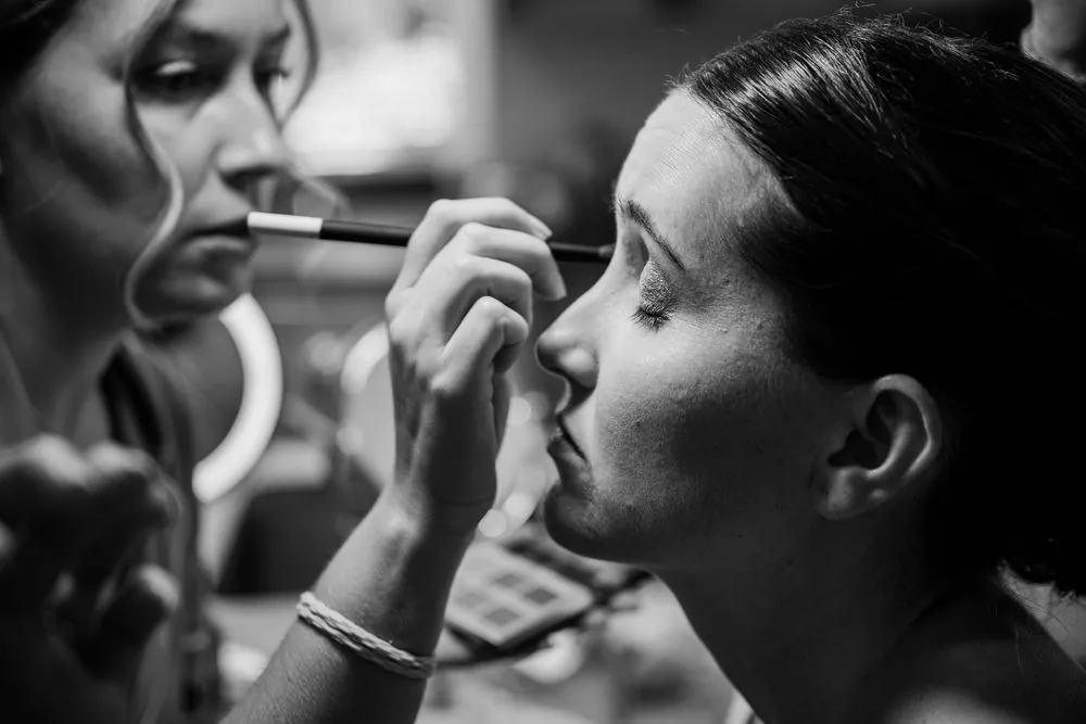 Black and white close view of the bride having her eye makeup applied