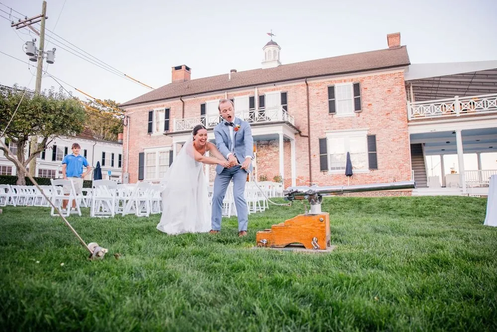 Isabelle and Bryce fire a small signal cannon on the lawn in front of the clubhouse