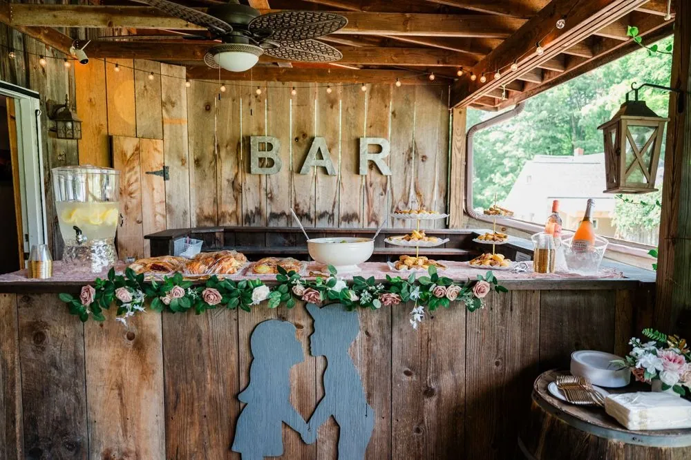 A rustic wood bar with greenery garland and hanging lanterns