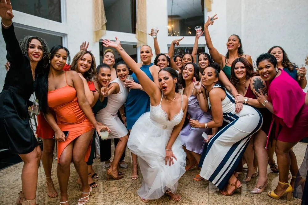 Karla throws her arms up in the middle of a crowd of women on the dance floor