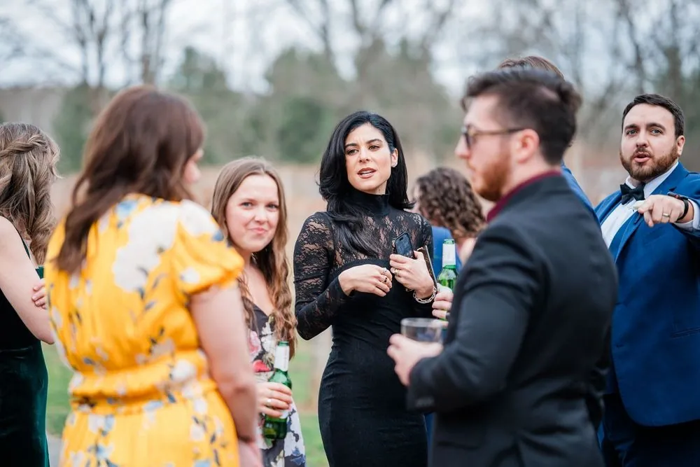 Guests talk and laugh together outside during cocktail hour