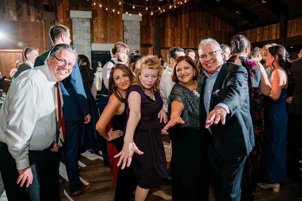 Guests pack the dance floor with arms out and wide grins