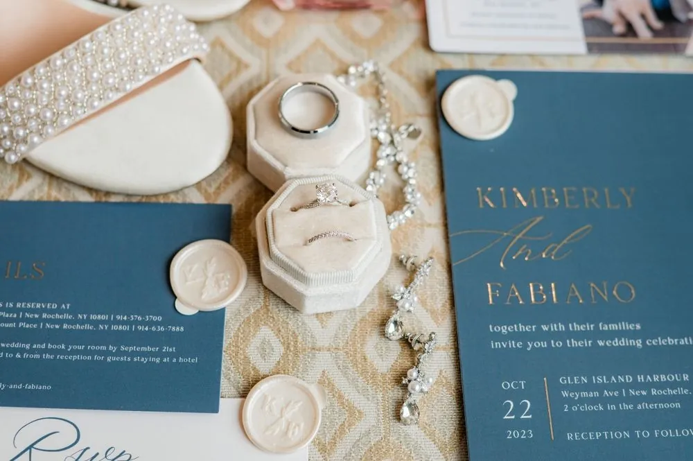 Slate blue invitation with gold lettering, wax seals, and rings in an ivory velvet box