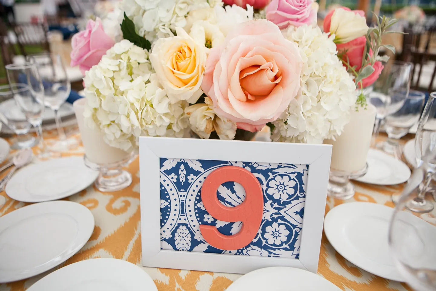 Table 9 on a blue and white patterned card beneath peach roses and white hydrangea