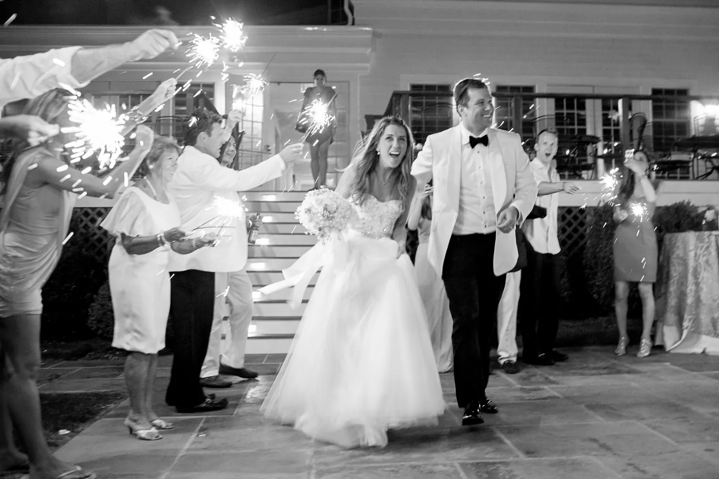 Black and white sparkler exit as Maddie and Dave run out between rows of guests