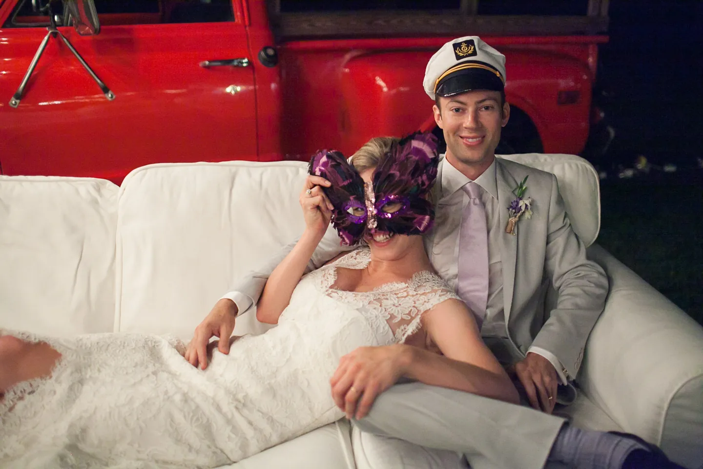 Marina and James lounge on a white sofa in a purple mask and captain's hat