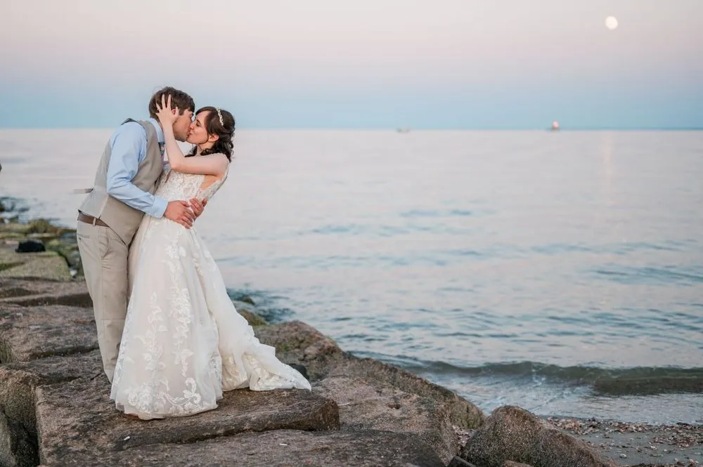 Dan dips Mary on the rocks at the water's edge as the sky turns pink