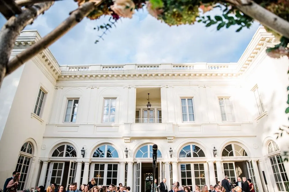Guests seated in the columned courtyard between the mansion's arched wings