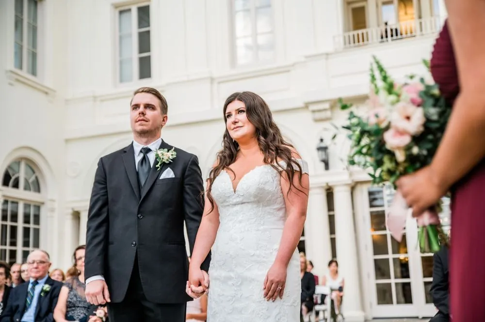 The groom walks the bride toward the front as guests look on