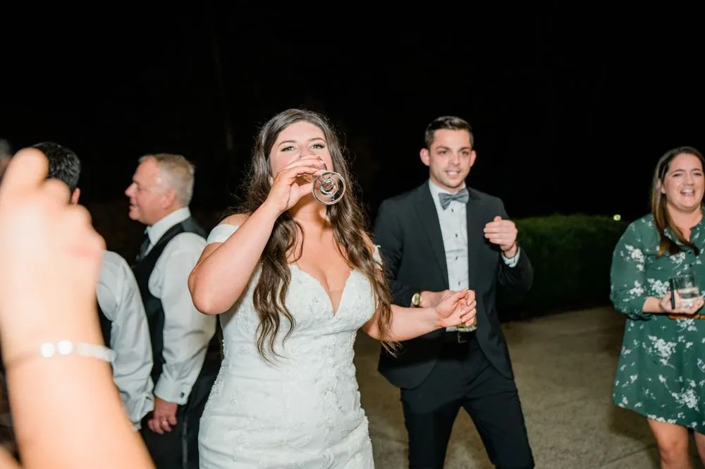 The bride laughs on the dance floor with guests late in the night