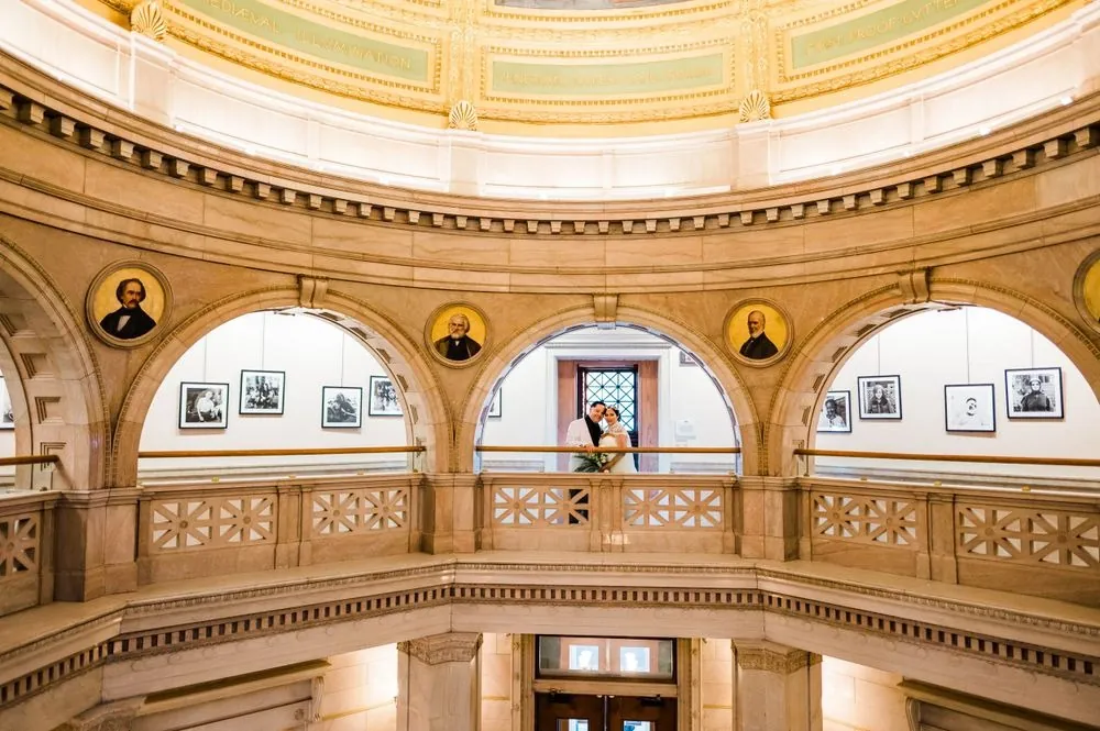 The domed rotunda inside the library glowing gold with carved balconies