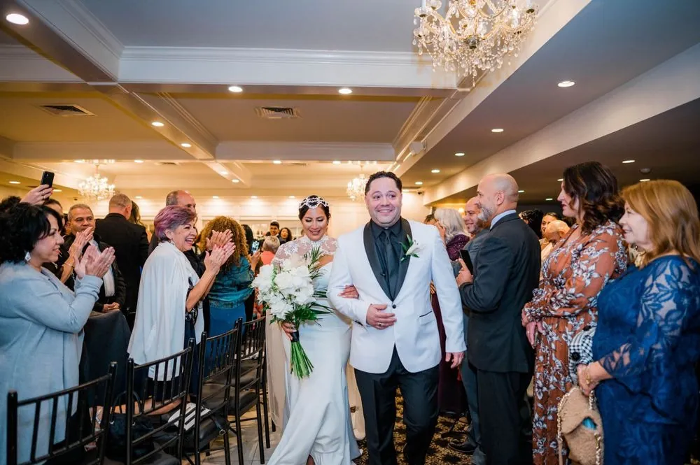 Guests applaud as the newlyweds walk back through the room