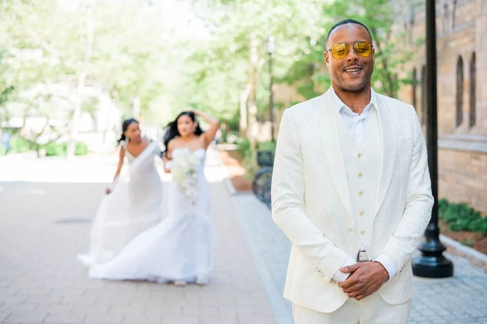 Sollisa walks toward DJ in her mermaid gown as he grins in his white suit